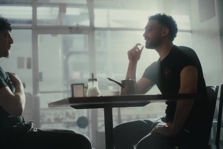 Two men sitting at a table talking