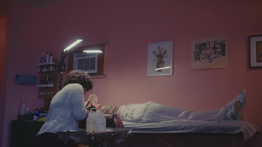 Tattoo artist works on a customers tattoo