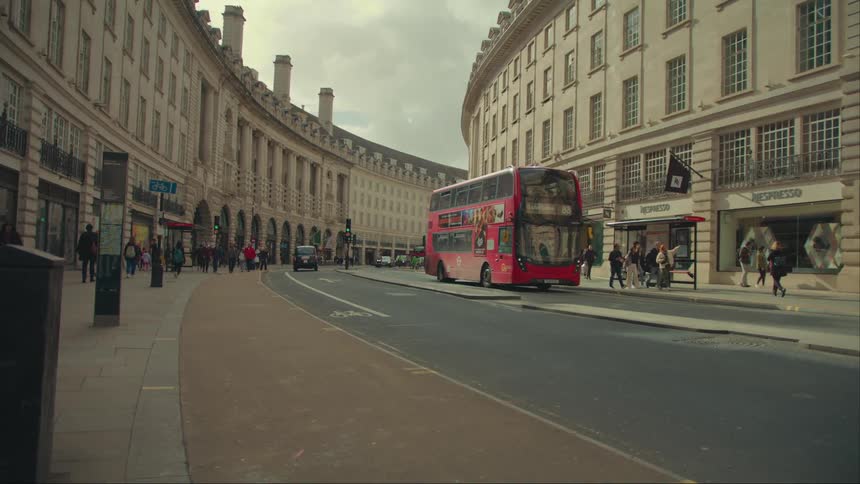 Street of a metropolis with pedestrians on a red public bus passing by