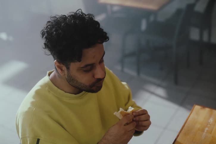 Man sitting eating a sandwich