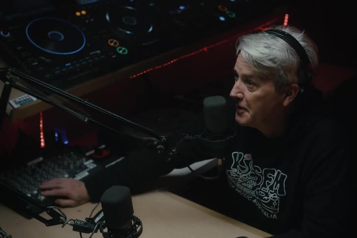 Man mixing music with a microphone in a studio with soft lighting