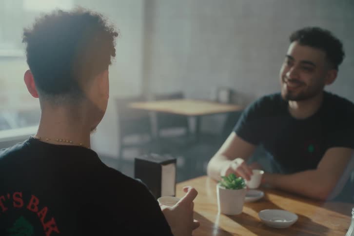 Two men sitting at a restaurant table drinking coffee