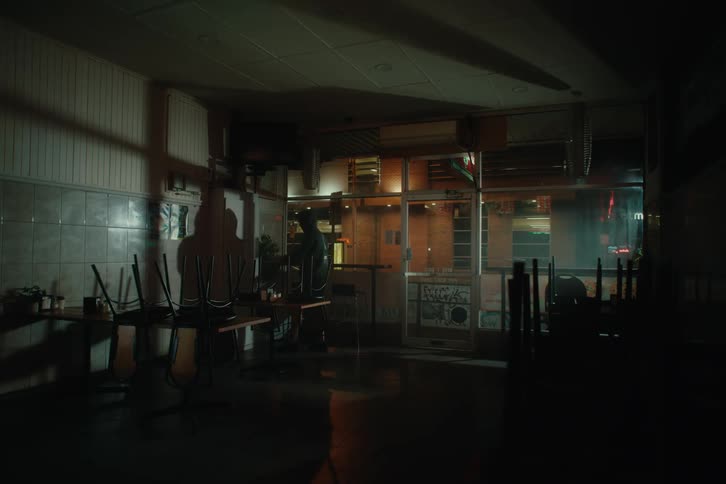 A shop owner enters his store in the early hours of the morning before dawn