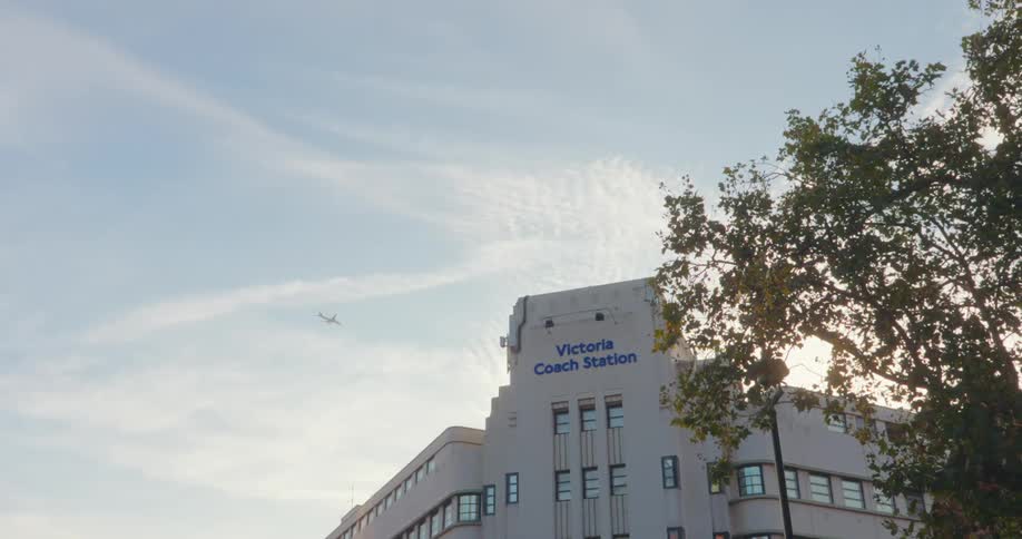 A view of a distant airplane in the sky above a building
