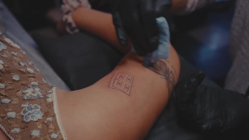 Gloved hand cleaning a womans tattoo