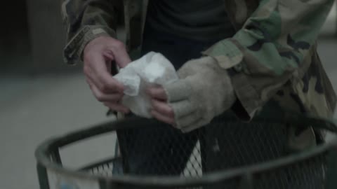 A man digs through the garbage removing some food