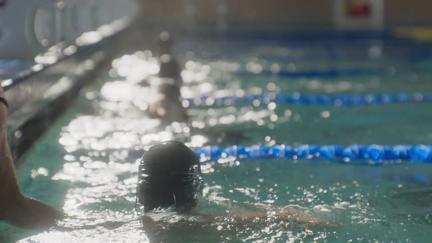 Men splash in a pool as they race to the finish