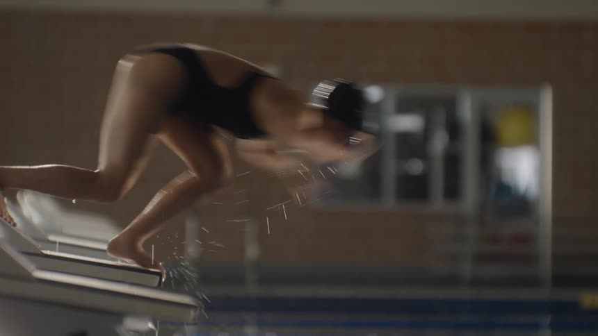 Woman in swimming cap and swimsuit jumping into pool
