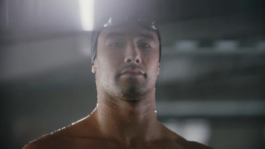 A man is wet and wearing goggles on his head