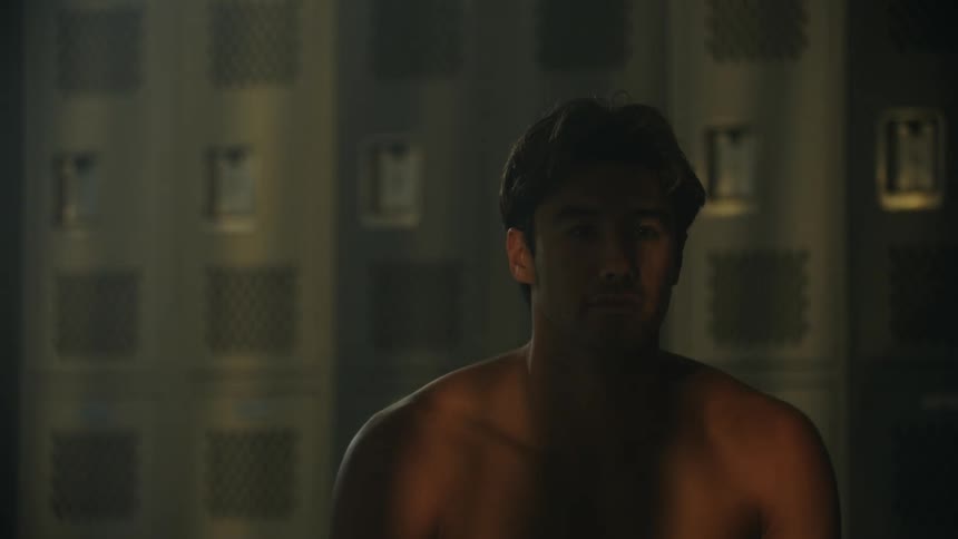 Shirtless man sitting focused in a locker room