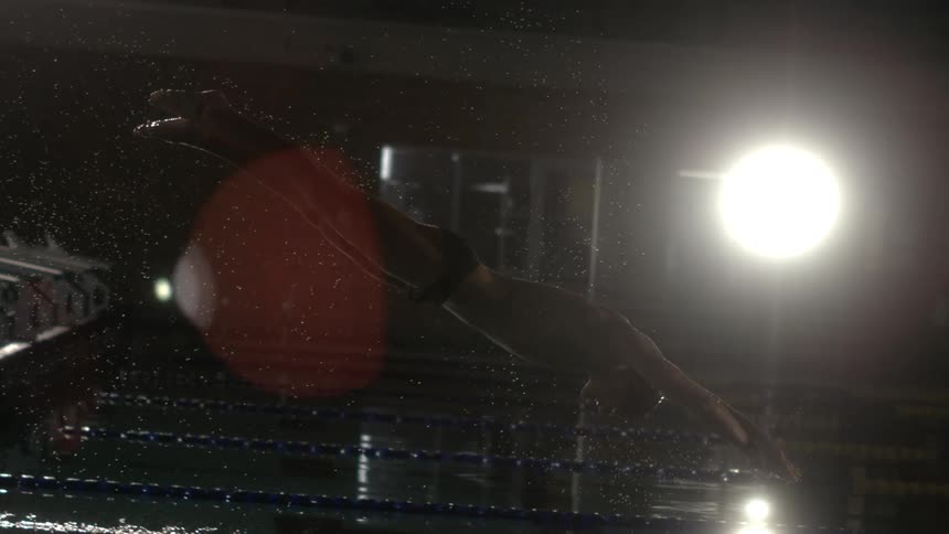 A swimmer dives into the pool