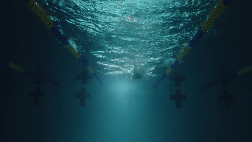 An underwater view of a swimmer gliding through a pool