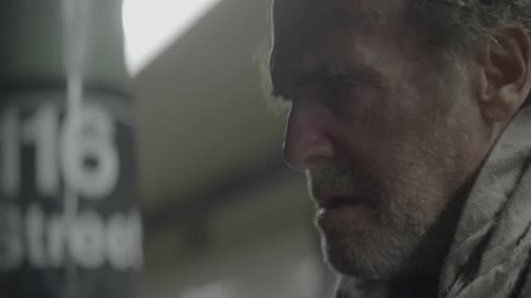 A man looks afraid while standing on a subway platform