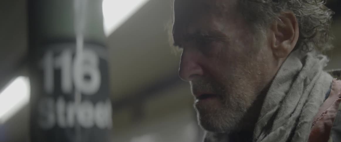 A man looks afraid while standing on a subway platform