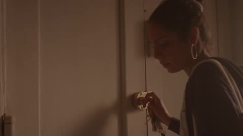 Woman securing her door with the key and then leaning against it