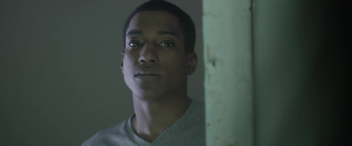 Young man looking past a doorway inside building