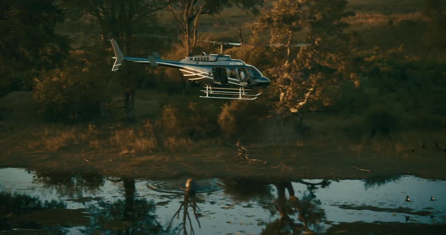 A helicopter flies over a body of water in nature