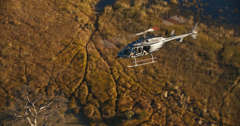 A helicopter flying over a savanna