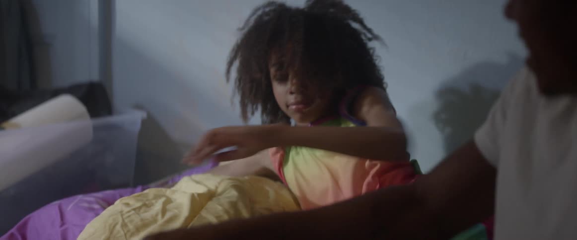 A man and a child are sitting on the bed talking