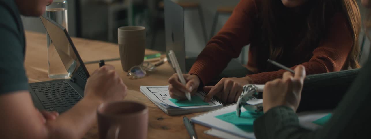 People are writing with pens in a book