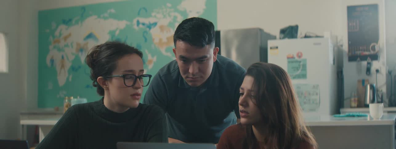 Students talk and look at a laptop