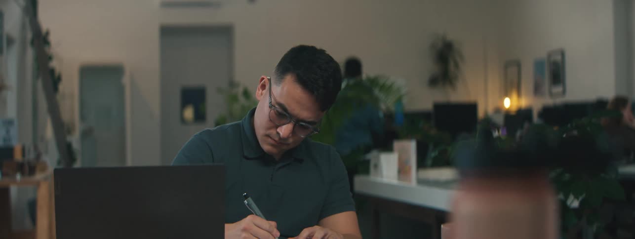 A man is writing with a pen