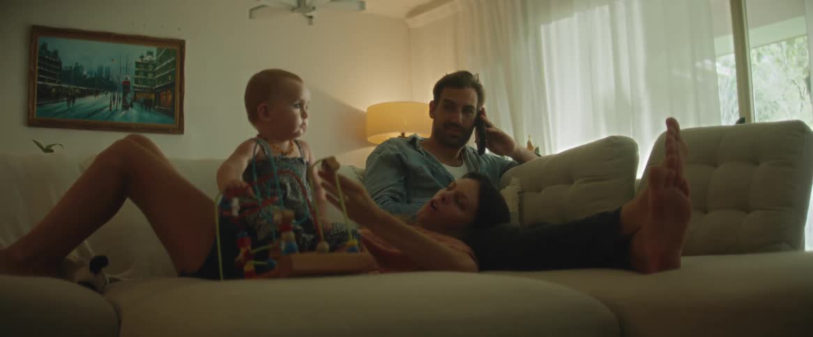 Family relaxes together in the couch at home
