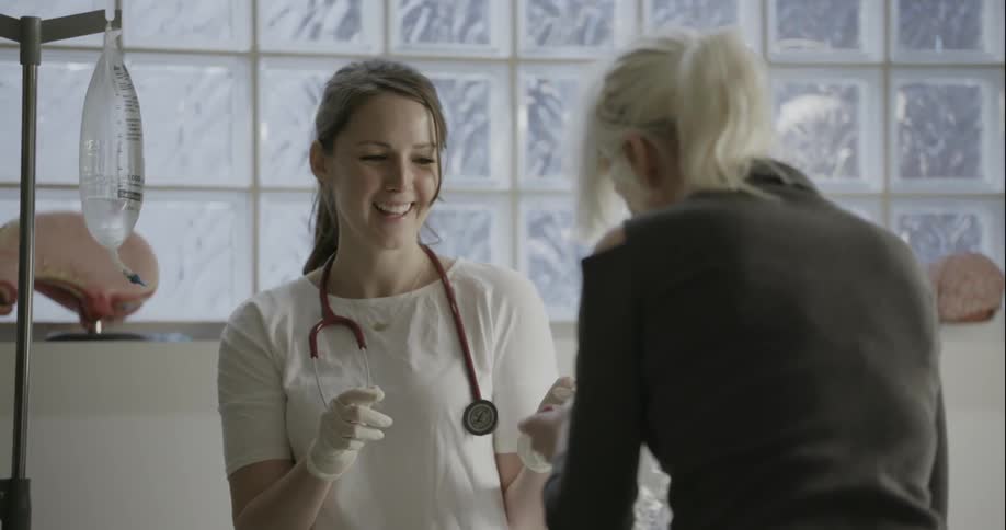 A female medical professional is assisting a patient