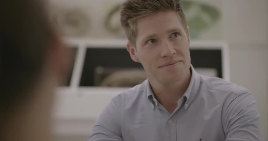Man talking and looking at other people sitting at table