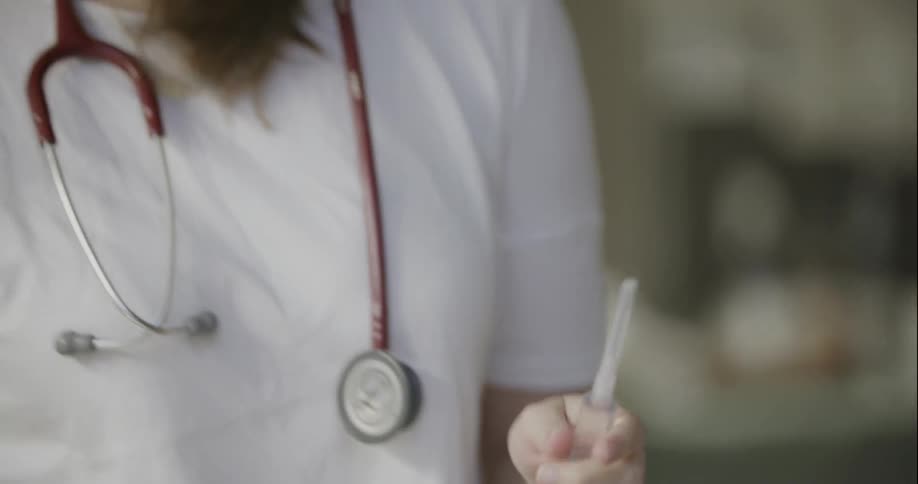 Woman placing the cap on the needle of a syringe