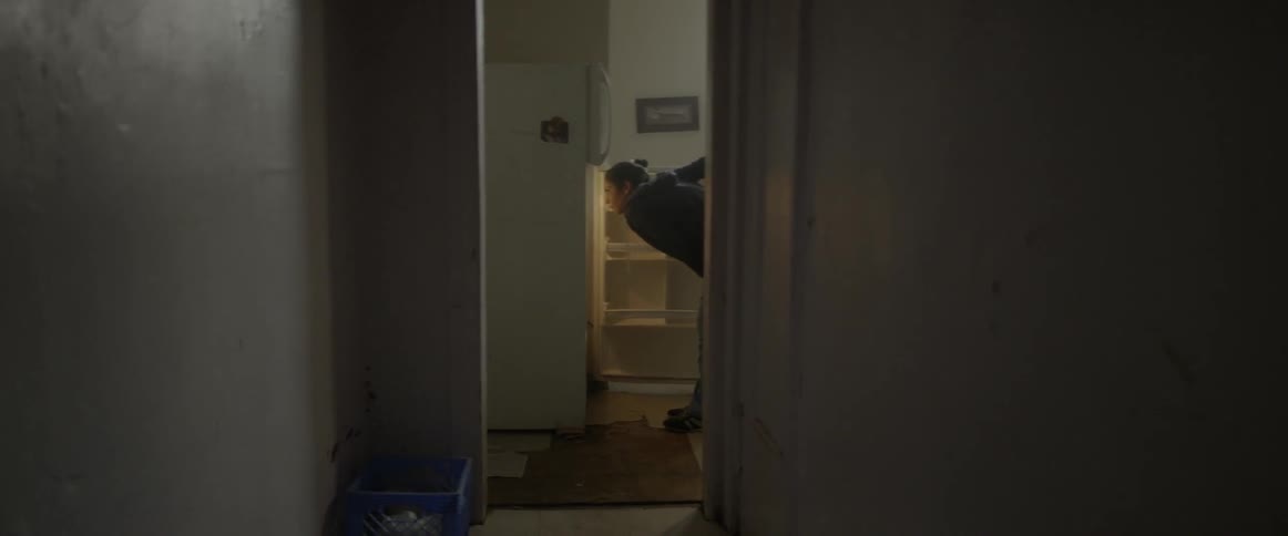 A woman examines her fridge for food