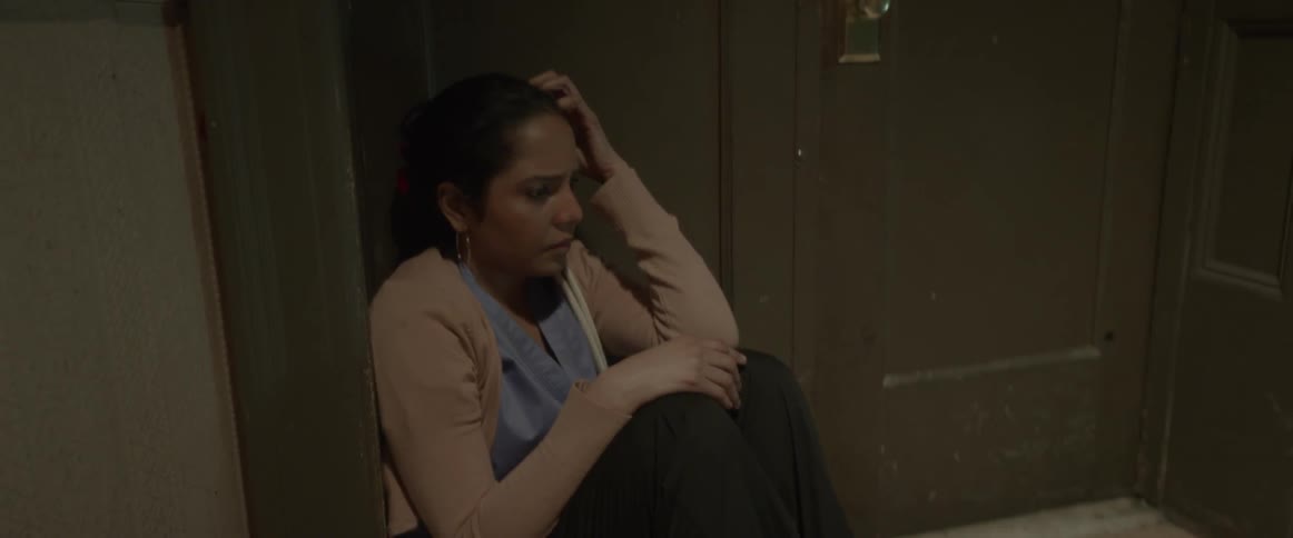 A stressed out woman sits in a doorway