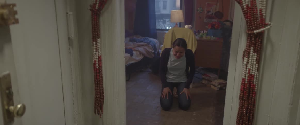 A young woman falls to the ground sobbing