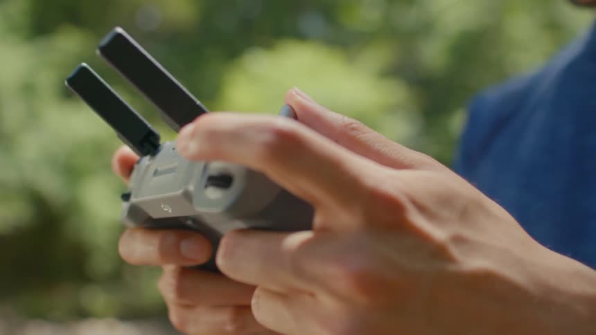 A mans hands holding a drones remote controller