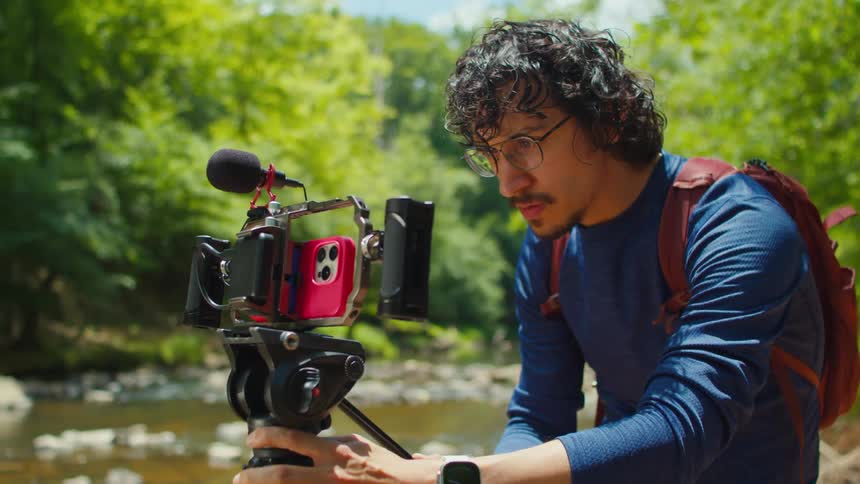 A hiker is filming in the forest