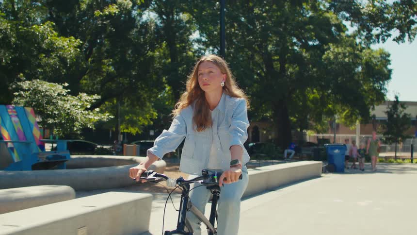 Young blonde woman riding a bike through the city