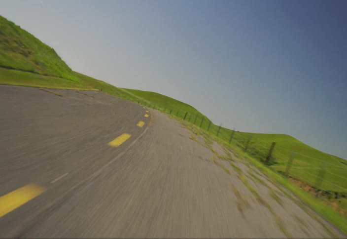 Moving on a road cutting through grassy hills