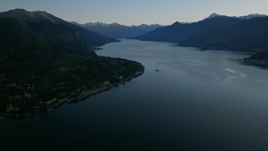 A boat floats off of a rural coastal community in a fjord