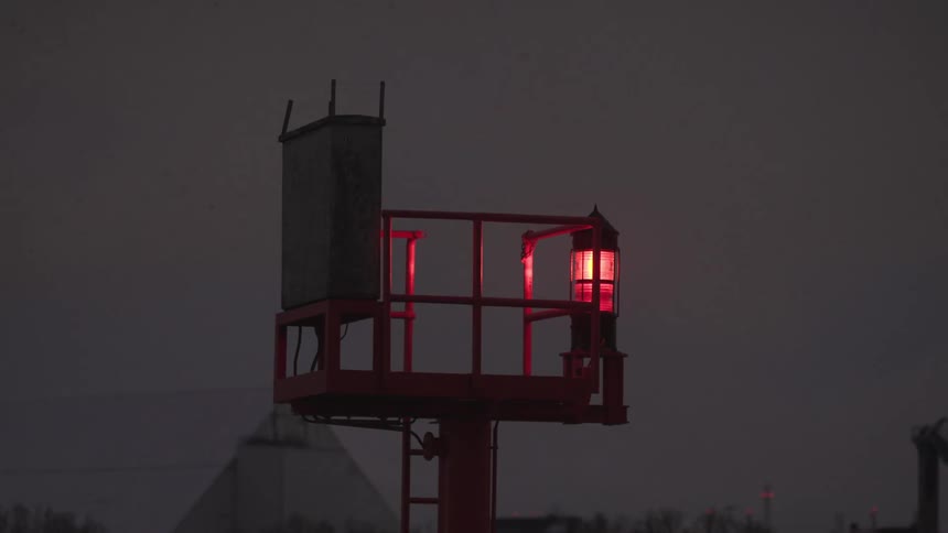A ladder leads to an open tower with a light connected on the edge