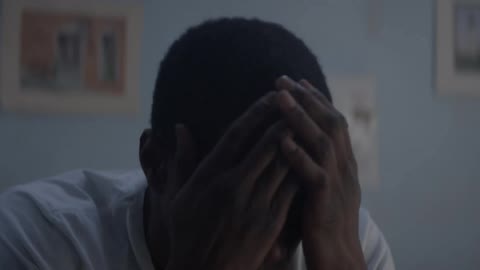 A boy gets up and rubs his face to wake up