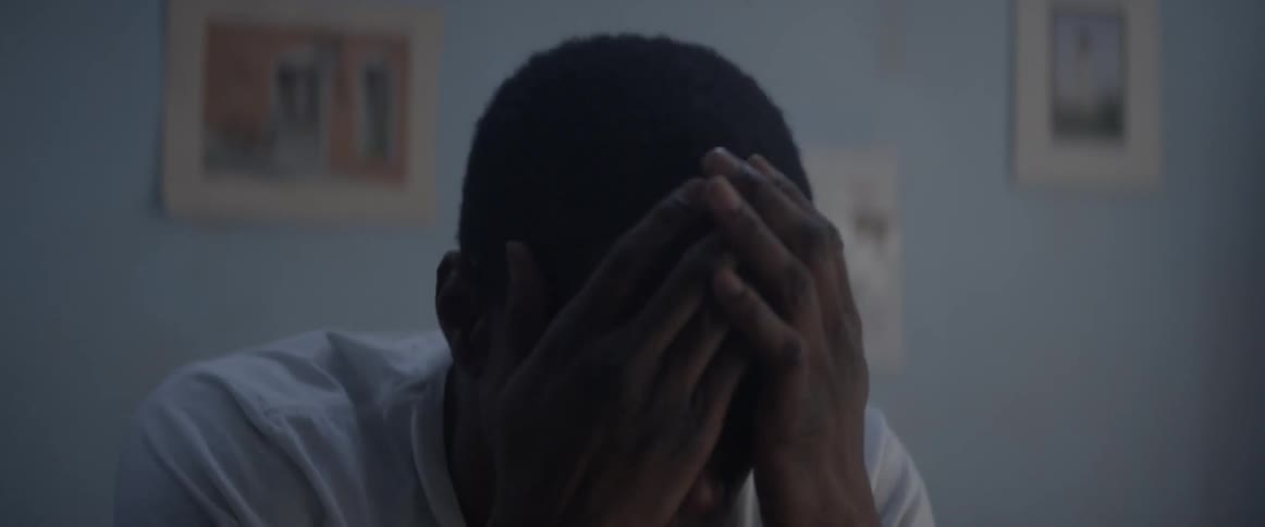 A boy gets up and rubs his face to wake up