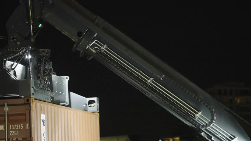 Large crane moves a cargo container overnight