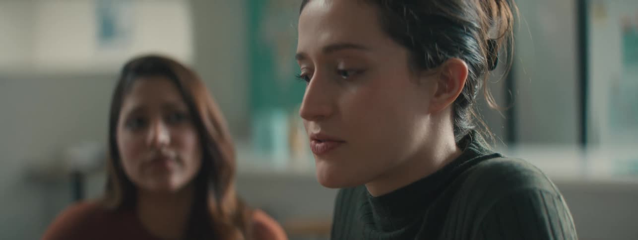 Two women sitting in an indoor space talking