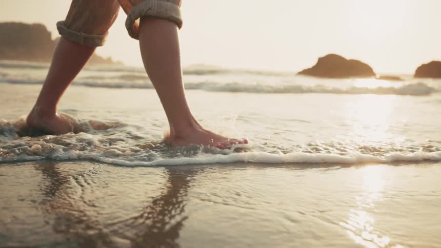 Legs of a man walking on the beach