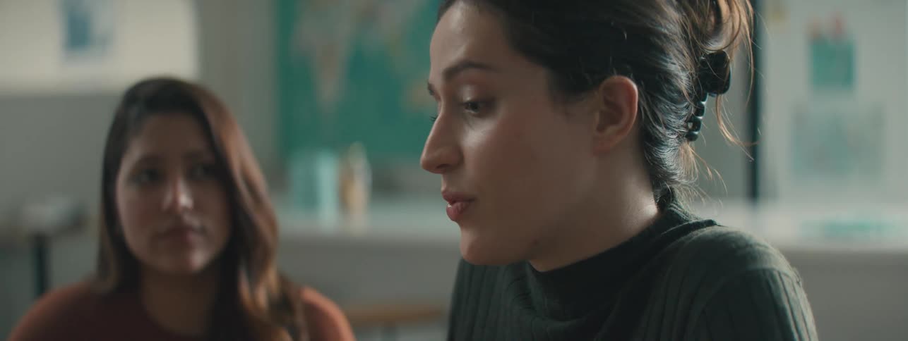 Close up of a woman explaining something to coworkers on a well lit office