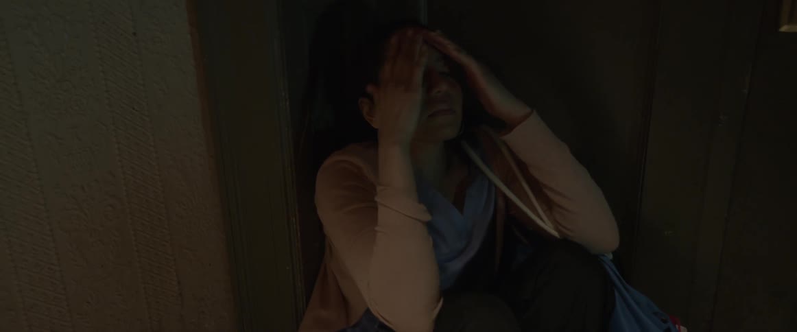 A woman shakes and twitches in a dim room