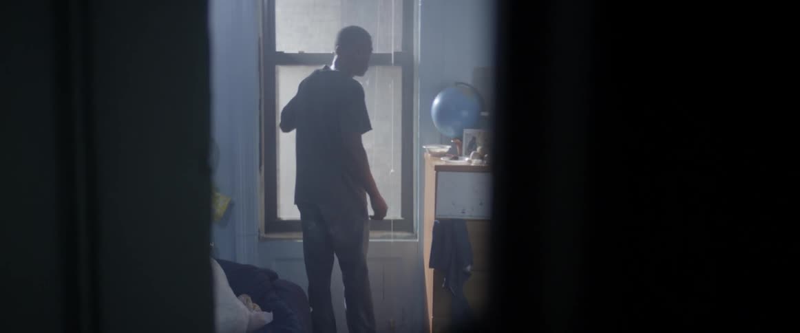 A teenage boy looking out a window when he hears something then goes to investigate