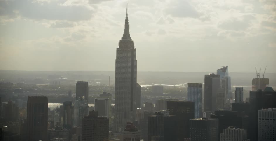 The empire state building rises above the other buildings ahead