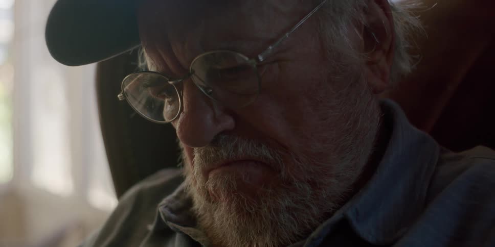 A man is looking at something while wearing glasses