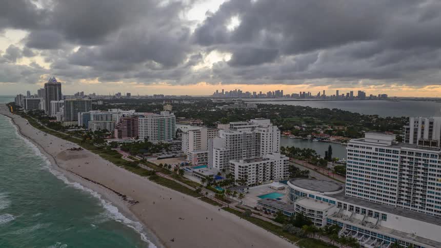 Aerial view of a hotel area on the edge of a beach with a cloudy sky